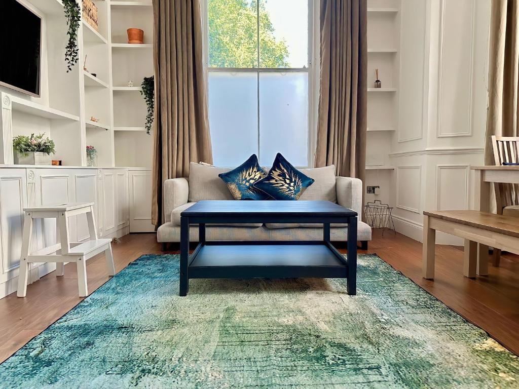a living room with a blue coffee table and a couch at Luxurious 2-Bedroom, 2-Bathroom Paddington Retreat with En-Suite TV Bed in London