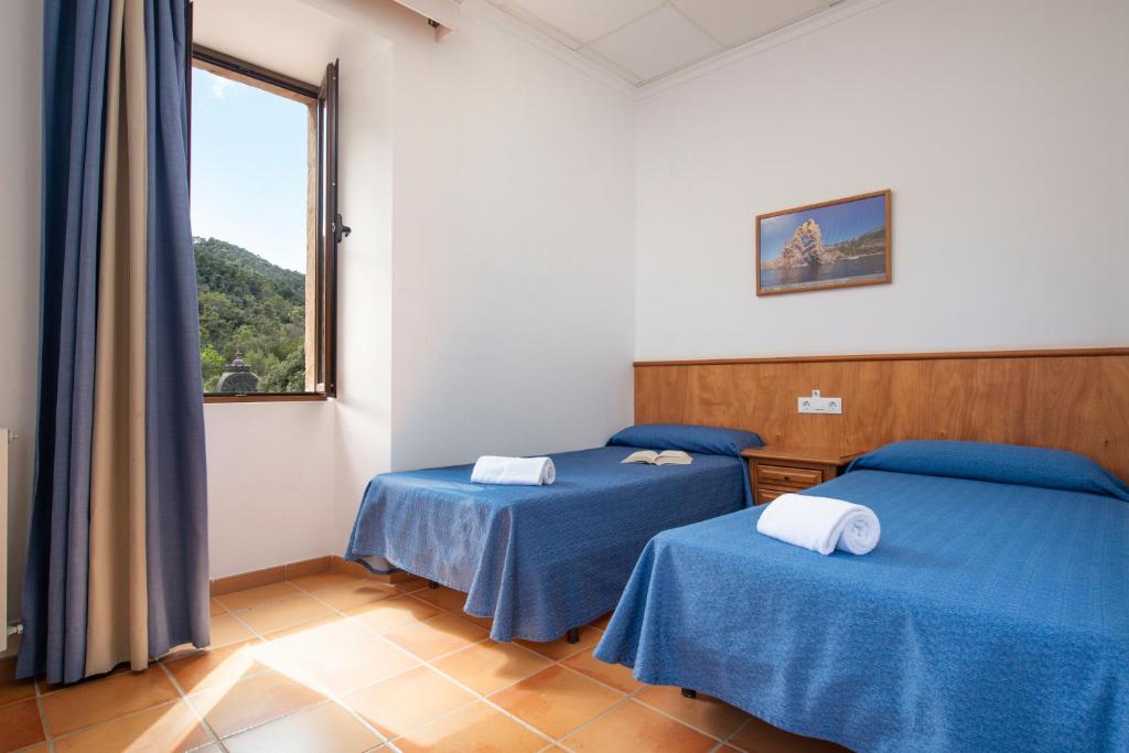 Postel nebo postele na pokoji v ubytování Santuari de Lluc