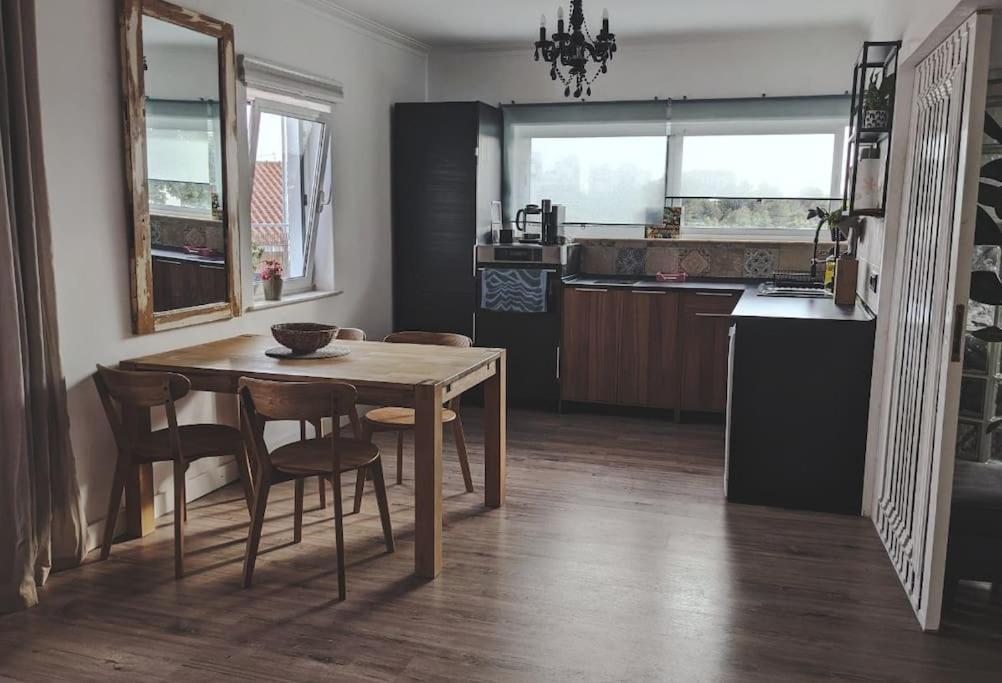een keuken met een houten tafel en stoelen en een tafel en een keuken met bij Stay In Cascais cosy apartment in Cascais