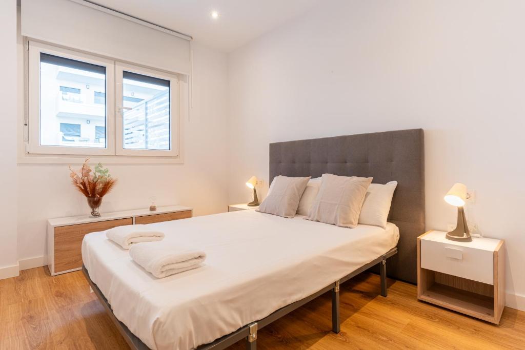 ein Schlafzimmer mit einem großen Bett mit weißer Bettwäsche und einem Fenster in der Unterkunft Trendy Homes Vega de Acá in Almería