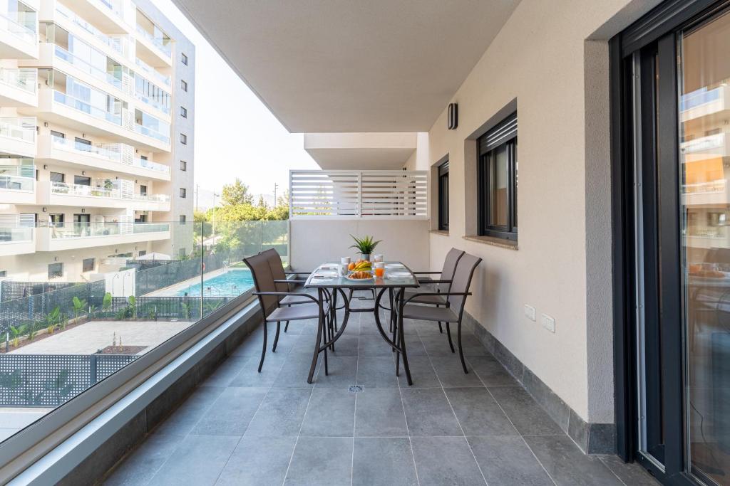 a patio with a table and chairs on a balcony at ATP Vega de Acá a 5 minutos de la Playa, Piscina Abierta y Parking Privado Gratis! in Almería