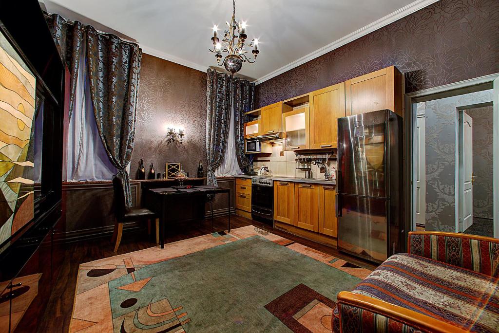 a kitchen with a couch and a table and a refrigerator at Longo on Bolshaya Konyushennaya in Saint Petersburg