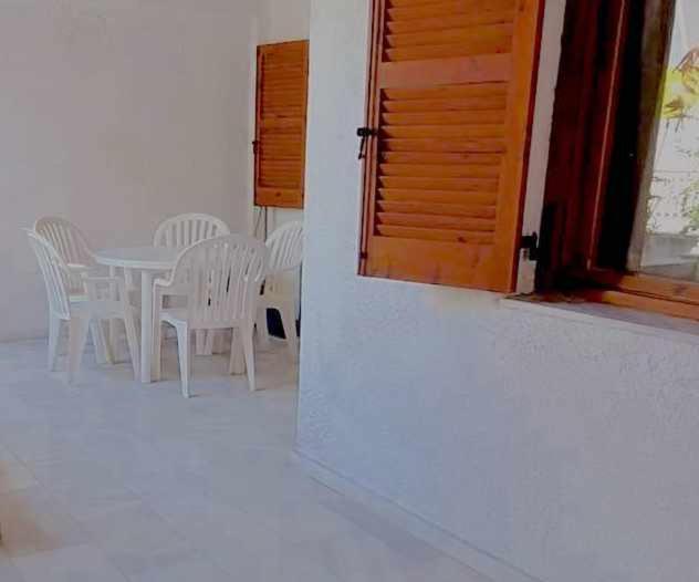 a white room with a table and chairs and a door at Cozy & Comfort in Polykhrono