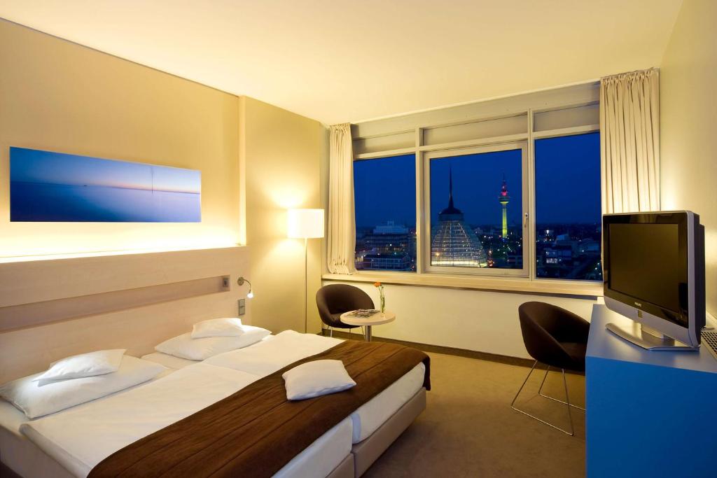 a hotel room with a bed and a window at Atlantic Hotel Sail City in Bremerhaven