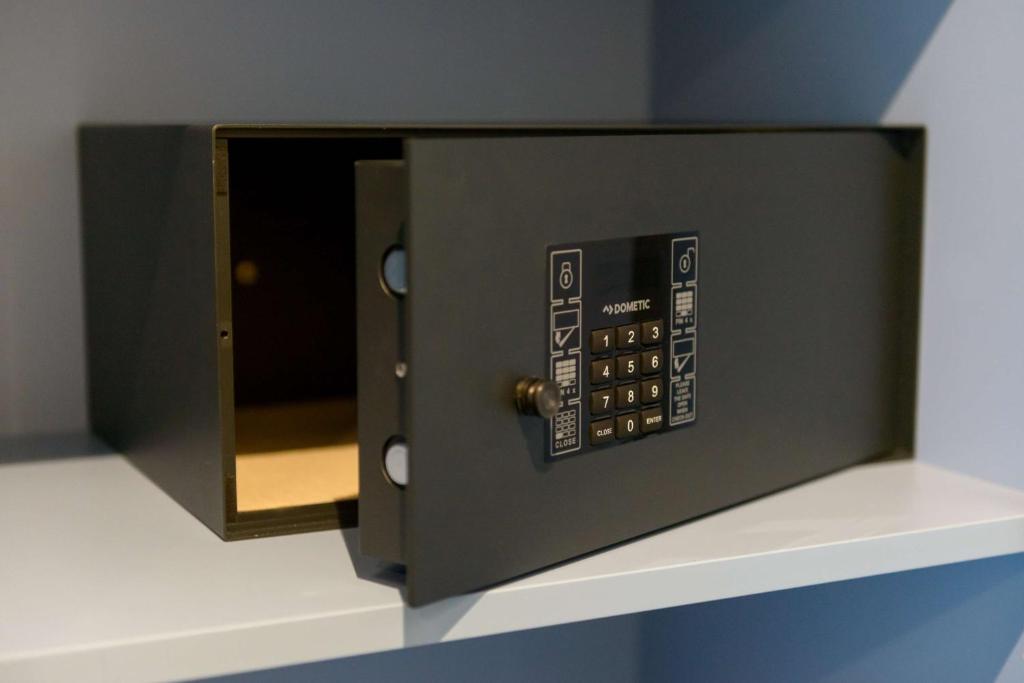 a black microwave oven sitting on a shelf at Atlantic Hotel Sail City in Bremerhaven