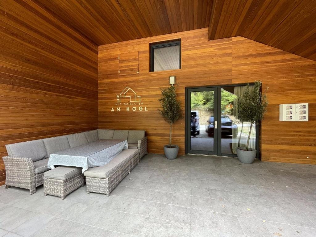 a patio with a couch and a table in front of a building at Gut Schlafen - Am Kogl in Hypolz