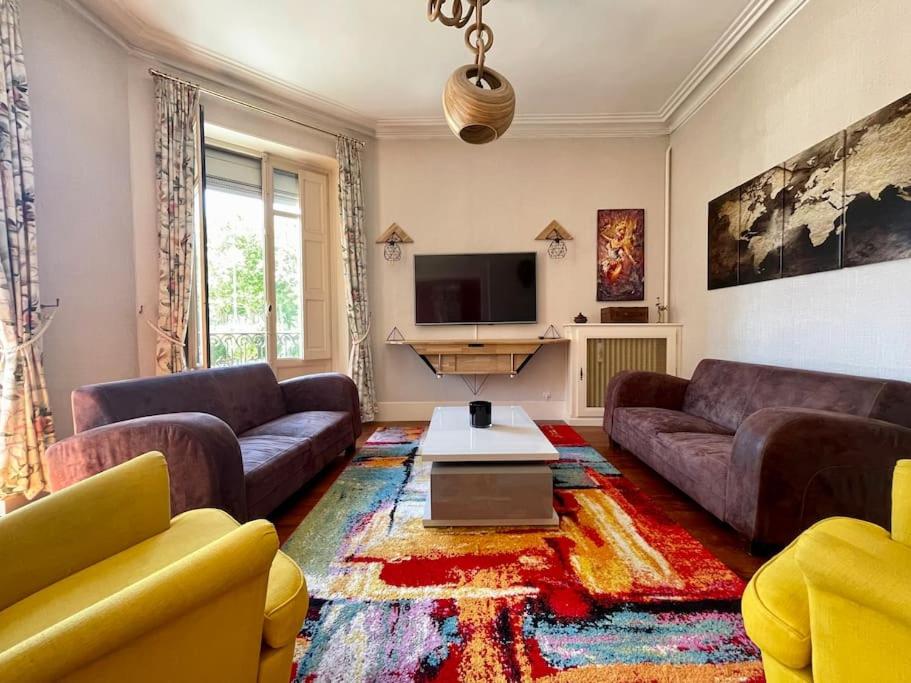 un salon avec deux canapés et une télévision dans l'établissement Le Balcon de Gambetta ※, à Carcassonne