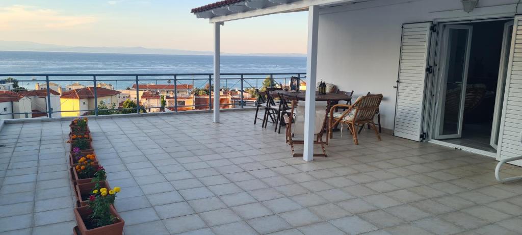 a balcony with a table and chairs and the ocean at Christina's panoramic view appartment in Polychrono