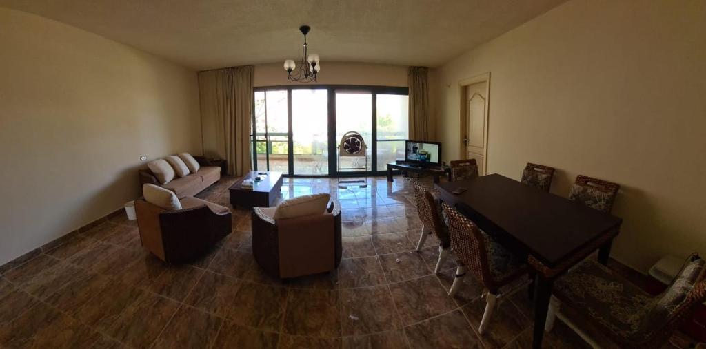 a living room with a couch and a table and chairs at Chalet in Mena 4 in Dawwār ‘Abd al ‘Aţī Abū ‘Ajūz