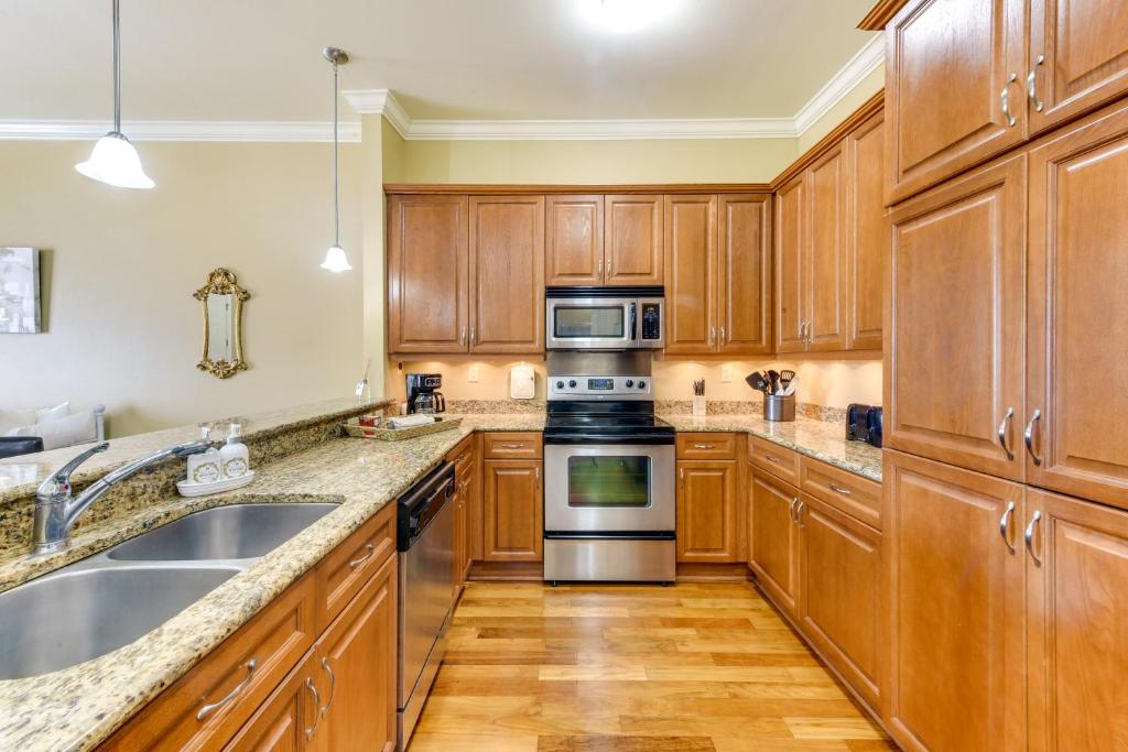 a kitchen with wooden cabinets and stainless steel appliances at Lovely Baton Rouge Condo about 1 Mi to LSU in Baton Rouge