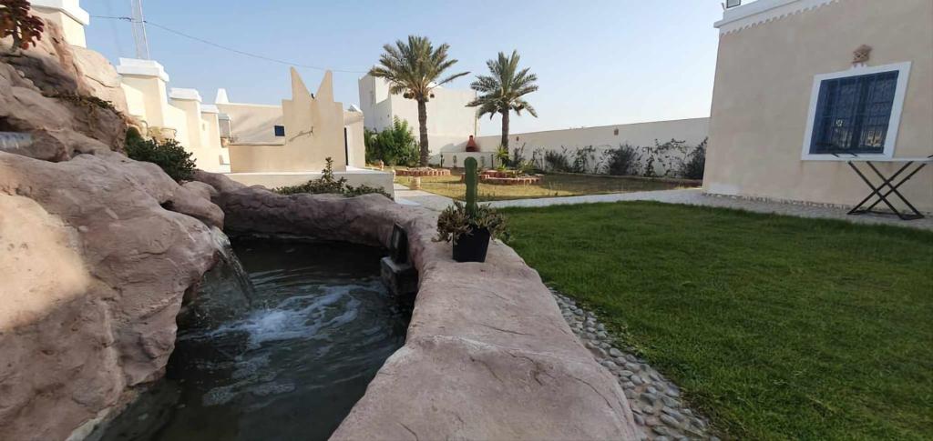 a water feature in a yard next to a house at La cascade in Houmt Souk