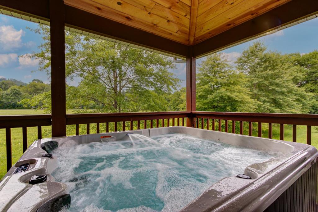 a hot tub on the back porch of a house at 3 Master Bedrooms - Sleeps 10 - Location - Game Room - Hot Tub in Pigeon Forge