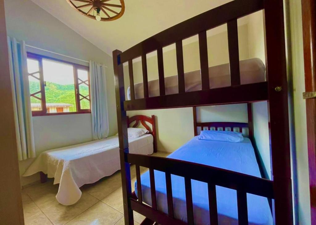 a bedroom with two bunk beds and a window at Casa de campo com Piscina in Santo Amaro da Imperatriz
