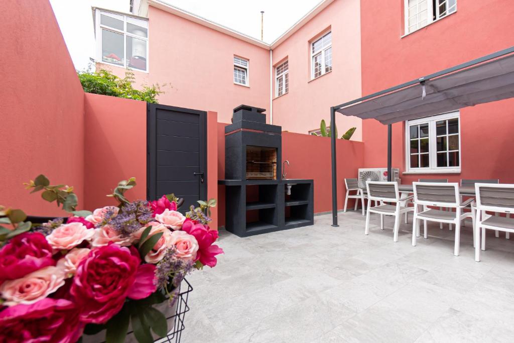 patio ze stołem, krzesłami i kwiatami w obiekcie Best House Center - with Garage w Porto