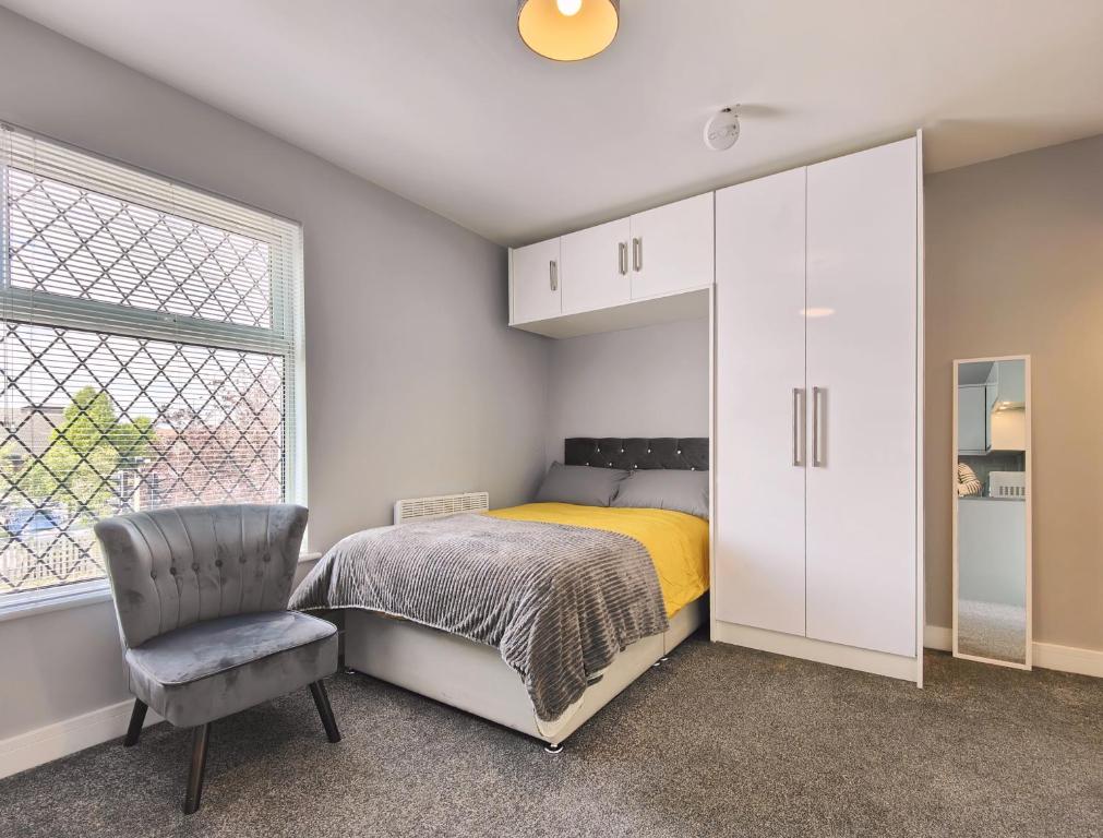 una camera con un letto e una sedia e una finestra di Charming Holiday Home in Hazel Grove - Self Catering Apartment 2 a Hazel Grove