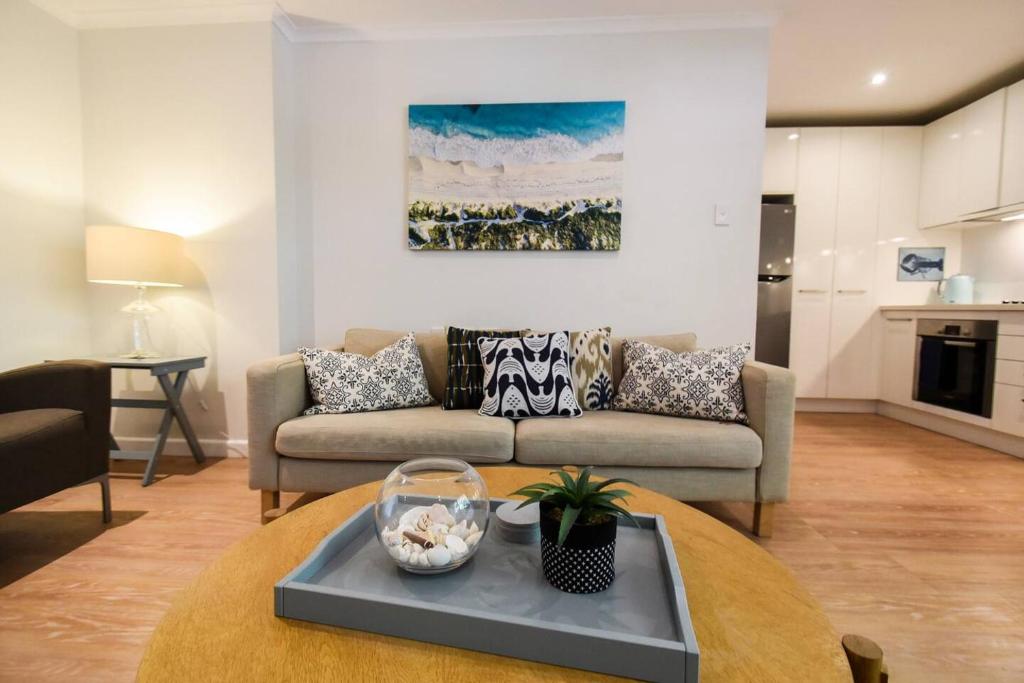 Resort-style Coastal Living with Balcony & Pool في سيدني: غرفة معيشة مع أريكة وطاولة