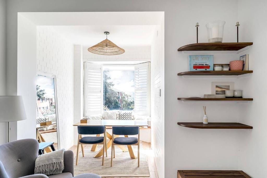 een woonkamer met een tafel en blauwe stoelen bij A South Bondi Family Hideout for Beach Aficionados in Sydney