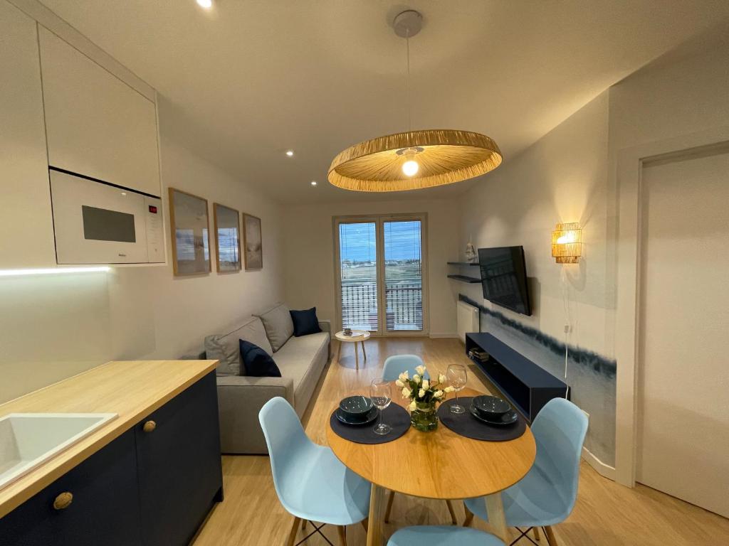 a kitchen and living room with a table and chairs at Apricot Sea View Premium Apartment in Władysławowo