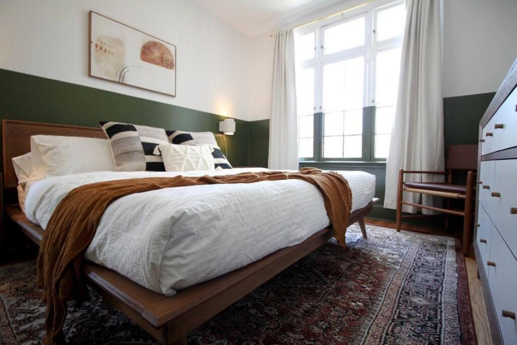 1 dormitorio con 1 cama grande y pared verde en Brand New Stylish 1BDR In Heart Of Rittenhouse Sq. Hosted By StayRafa, en Filadelfia
