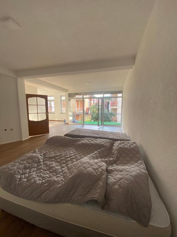 1 cama grande en un dormitorio con ventana grande en Struga Apartments, en Struga