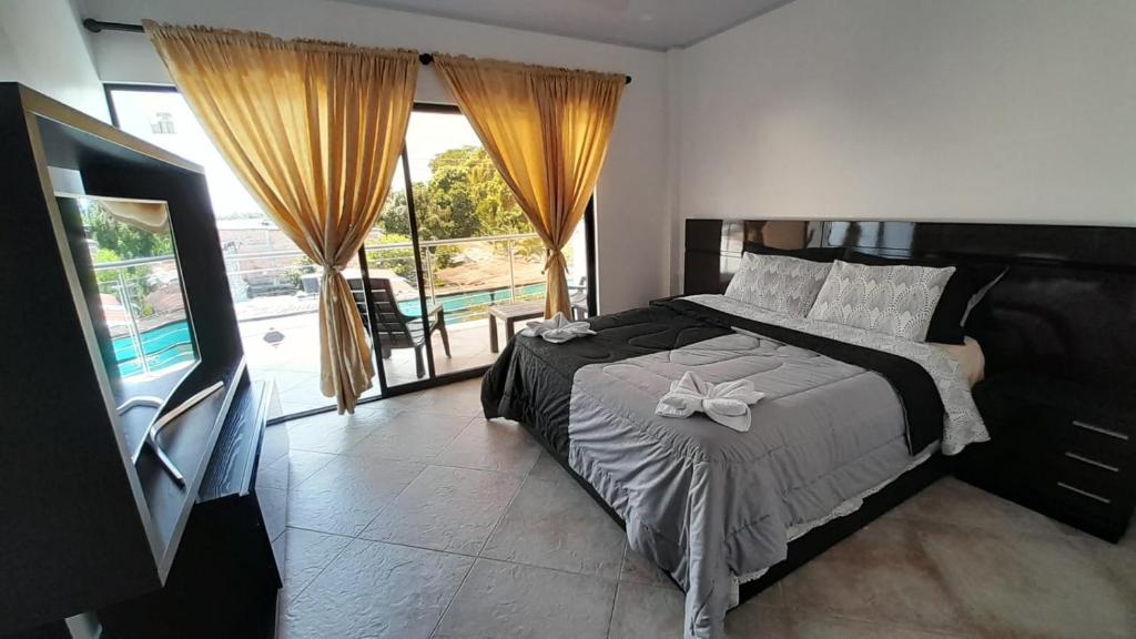a bedroom with a bed and a large window at Katara Boutique Hotel in Mariquita