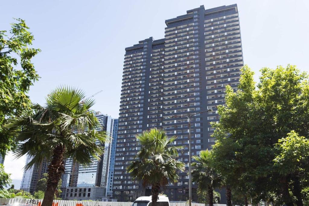 Un edificio alto con palmeras delante. en Апартамент с шикарными видами, en Batumi