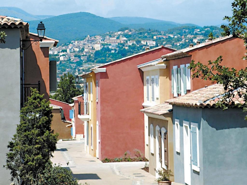 Une rangée de maisons dans une ville avec des montagnes en arrière-plan dans l'établissement Villa in Fayence with Private Pool & Bubble Bath, à Callian