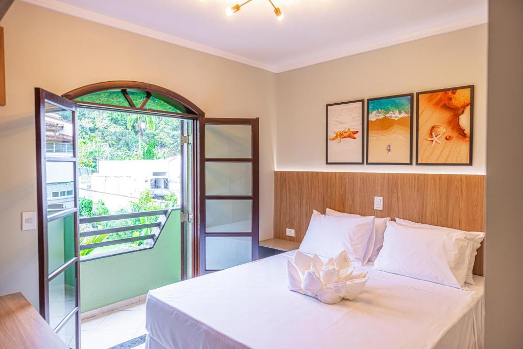 a bedroom with a white bed and a window at Ubatuba Eco Hotel in Ubatuba