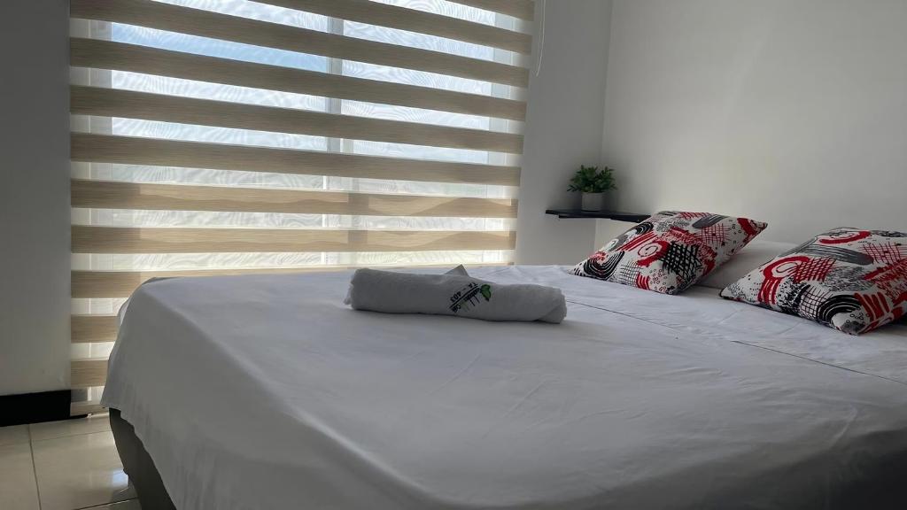ein weißes Bett mit zwei Kissen darüber in der Unterkunft Guaduales del café a 403 in Montenegro