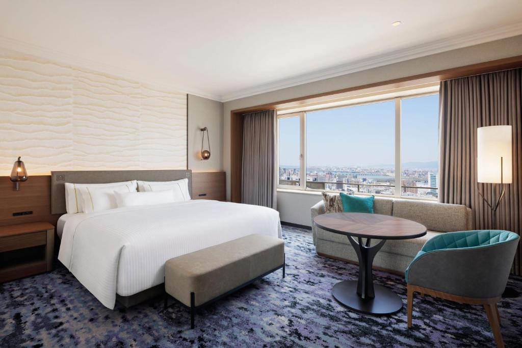 a hotel room with a bed and a large window at The Westin Osaka in Osaka