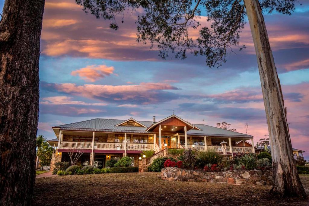 a house with a sunset in the background at Robyn's Nest Lakeside Resort in Merimbula