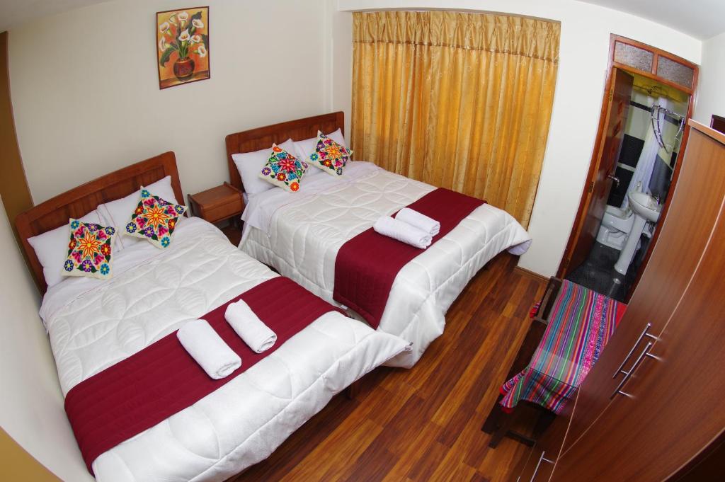 dos camas sentadas una al lado de la otra en un dormitorio en Hostal Mirador Korichaska, en Puno