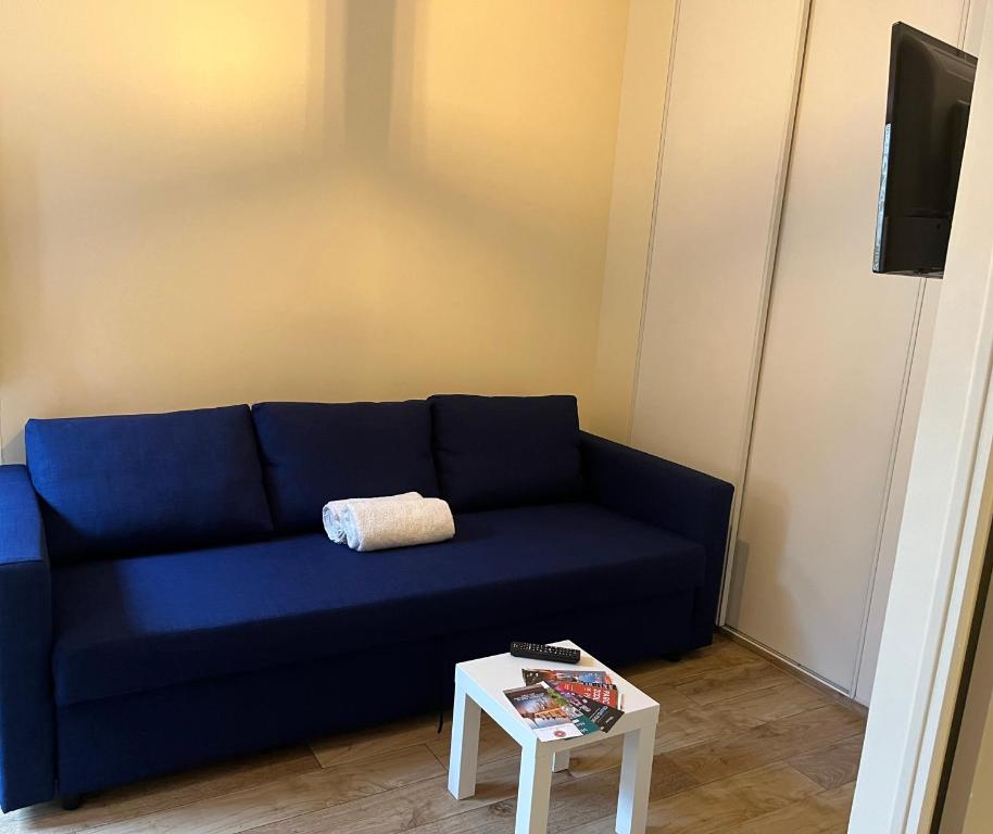 a blue couch in a living room with a table at Joli studio proche gare in Brétigny-sur-Orge