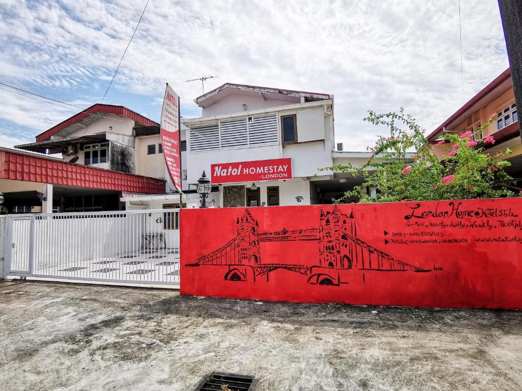 una parete rossa con l'immagine di un treno sopra. di Semi detached At Tabuan Jaya,13BR By Natol Homestay-London a Kuching