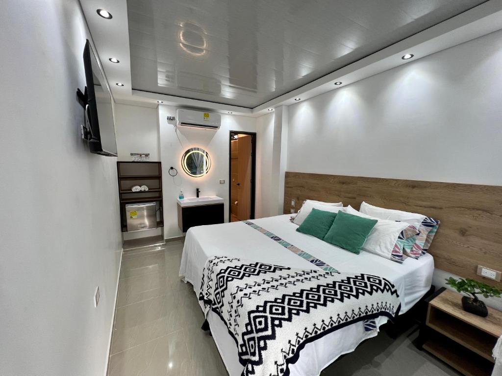 a bedroom with a large bed and a tv at HOTEL TORRE DELUXE ¨SANTORINI¨ in Doradal