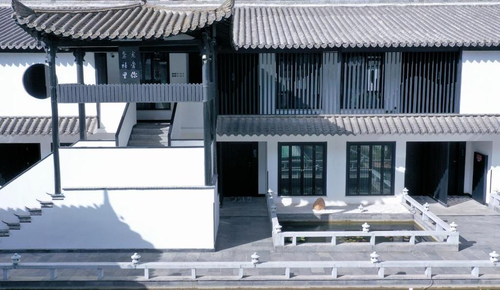 a white building with a bench in front of it at Xijian Hotel - Kunming Dongfeng East Road Dashuying Metro Station in Kunming