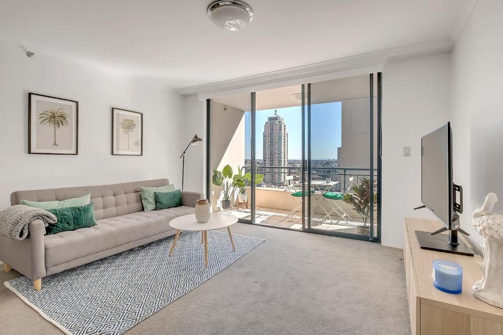 a living room with a couch and a tv at Top of the Town with Sydney CBD at its Doorstep in Sydney