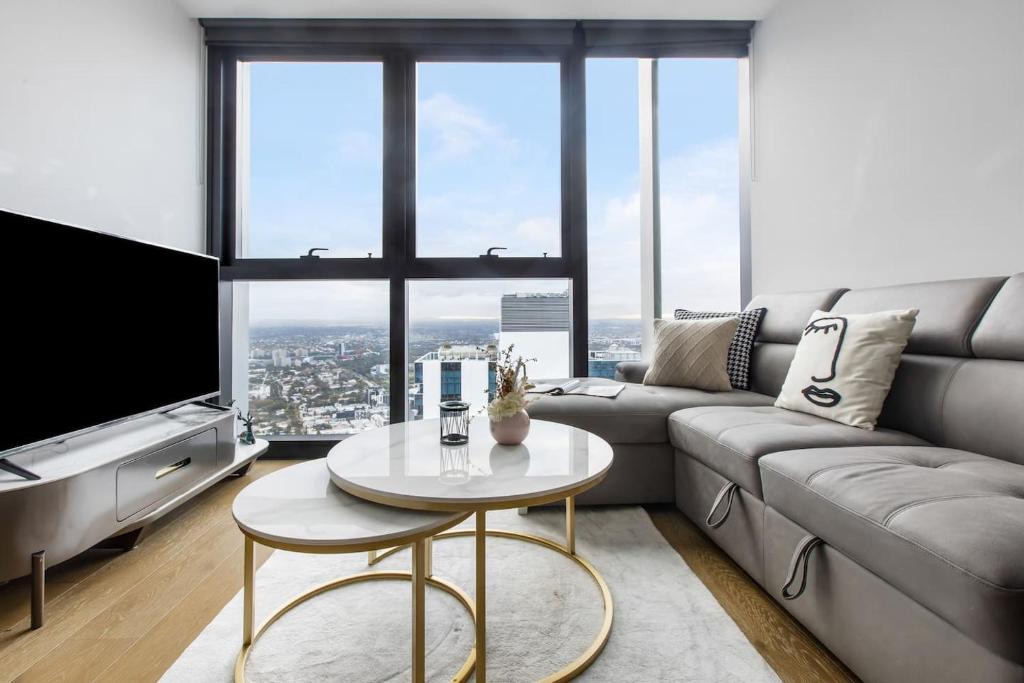 un soggiorno con divano e tavolo di The View on Elizabeth - Chic City Centre Living a Melbourne