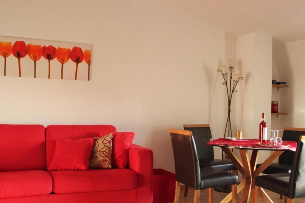 een woonkamer met een rode bank en een tafel bij Appartamento con Vista Lago in Lorica