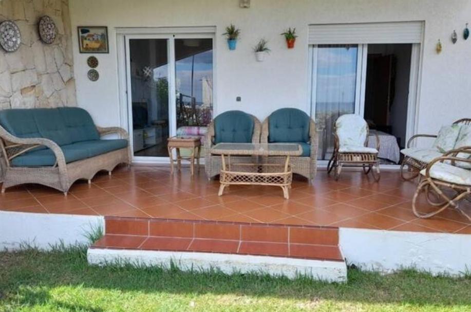 een patio met stoelen en een tafel op een veranda bij Appartement Al cudia smir in Fnidek