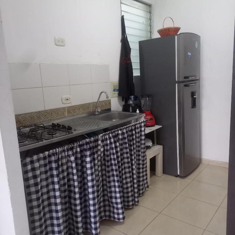 a kitchen with a stove and a refrigerator at Habitación en Valledupar in Valledupar