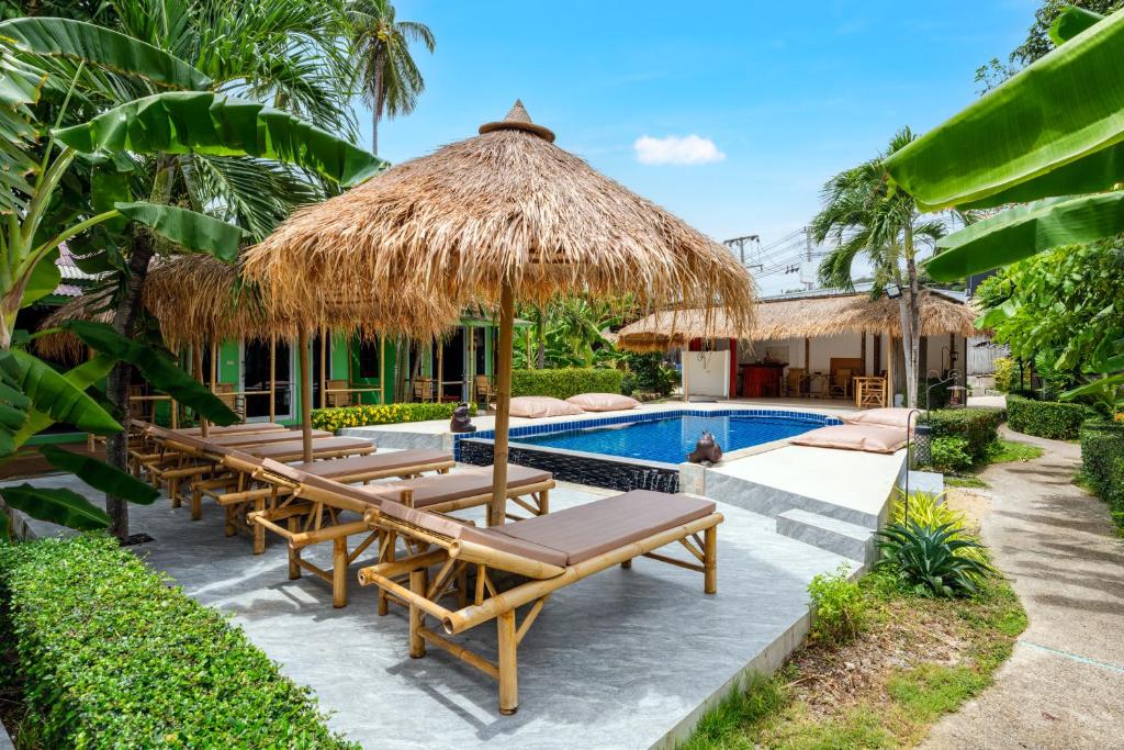 un complexe avec une piscine dotée de chaises longues et d'un parasol dans l'établissement Avocado Koh Samui, à Bophut 