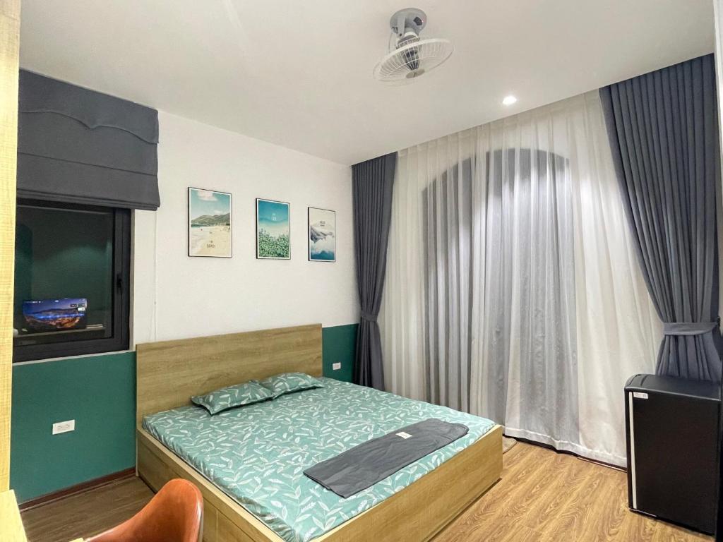 Schlafzimmer mit einem Bett, einem TV und einem Fenster in der Unterkunft Homestay ocean park 2,3 in HÆ°ng YÃªn