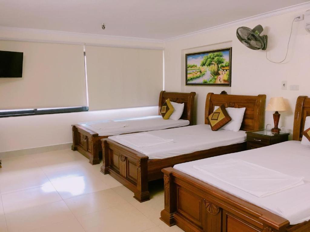 a room with three beds and a flat screen tv at Phúc Quý Hotel - 149B Lê Duẩn - by Bay Luxury in Hanoi