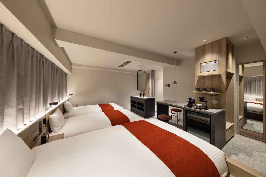 a hotel room with a bed and a desk at the b namba-kuromon in Osaka