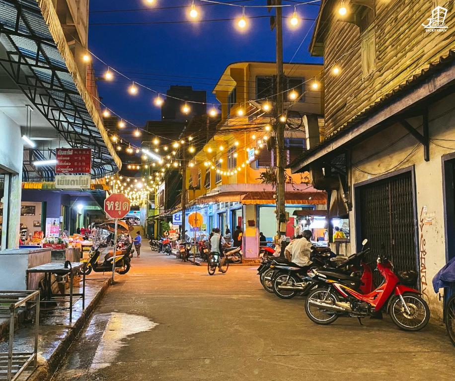 een groep motorfietsen die 's nachts op straat geparkeerd staan bij Jacky Chan Hotel in Betong
