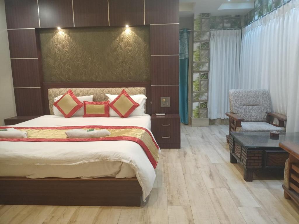 Dhuburi的住宿－The Brahmaputra Hotel，一间卧室配有一张大床和一把椅子