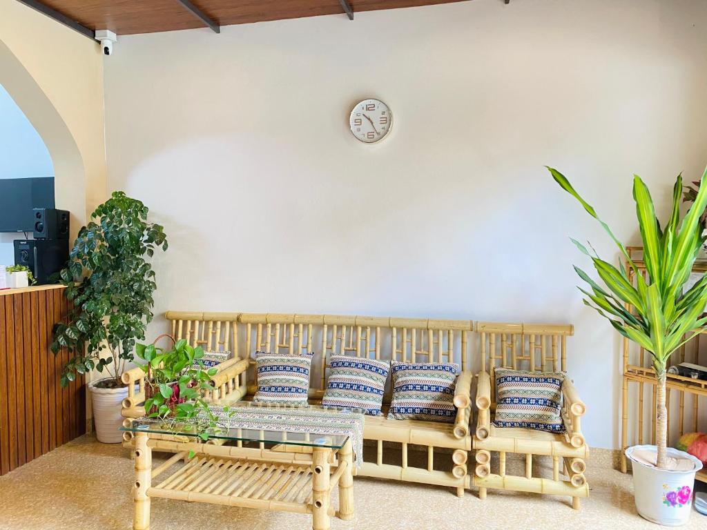 a living room with a couch and a clock on the wall at DH Homestay Cao Bằng in Cao Bằng