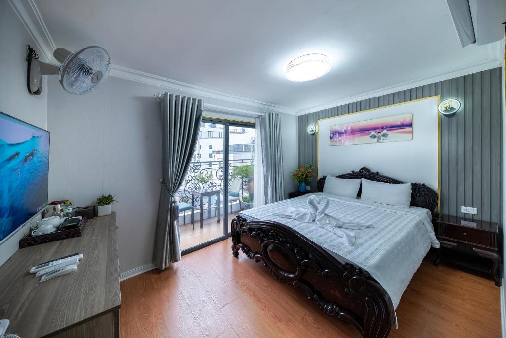 1 dormitorio con 1 cama grande y balcón en Hanoi Sofia Hotel en Hanói