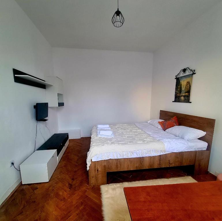 a bedroom with a bed and a chair in it at Mural Art Apartament in Petroşani